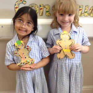 girls holding art gingerbread men