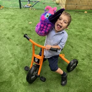 student holding a toy on a bike